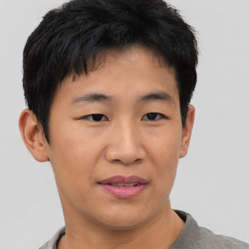 Joyful asian young-adult male with short  black hair and brown eyes