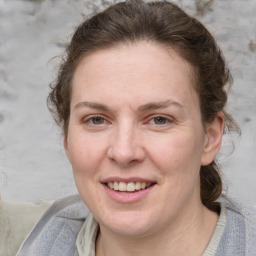 Joyful white adult female with medium  brown hair and grey eyes