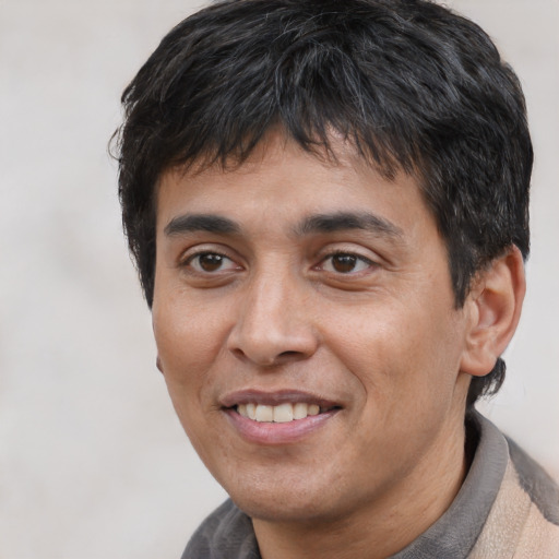 Joyful white adult male with short  black hair and brown eyes
