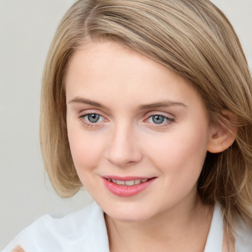 Joyful white young-adult female with medium  brown hair and blue eyes