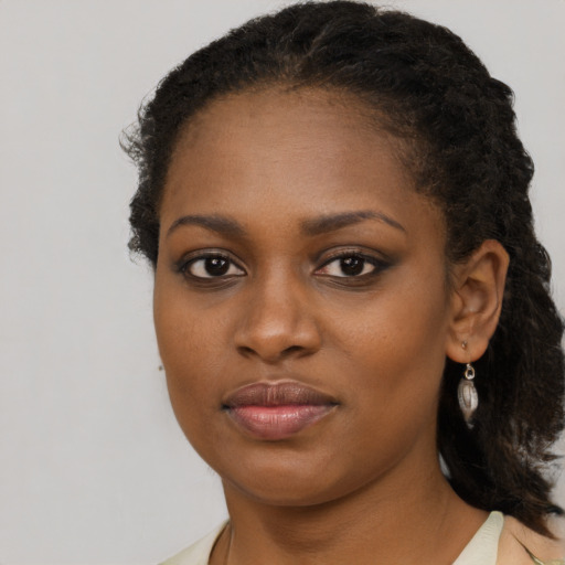 Joyful black young-adult female with long  brown hair and brown eyes