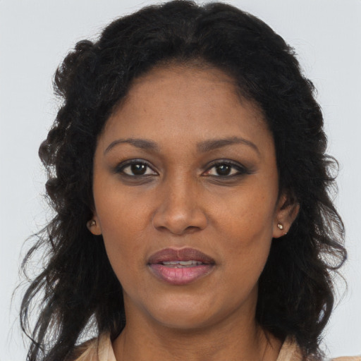 Joyful black adult female with long  brown hair and brown eyes