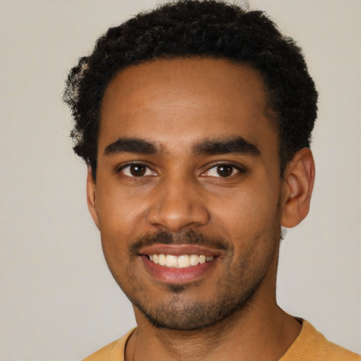 Joyful black young-adult male with short  black hair and brown eyes