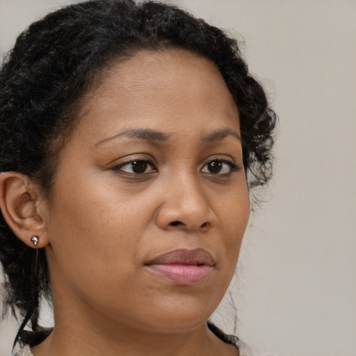 Joyful black young-adult female with medium  brown hair and brown eyes