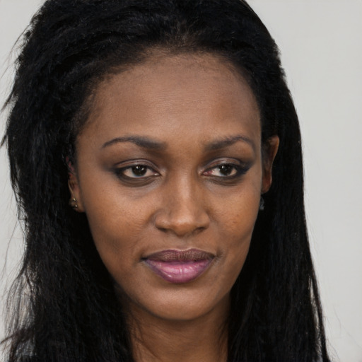 Joyful black young-adult female with long  brown hair and brown eyes