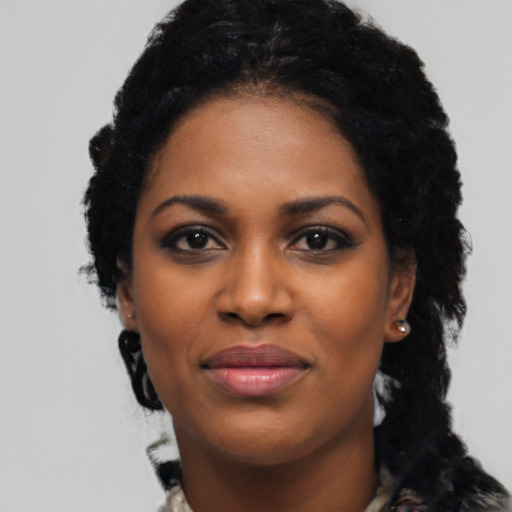 Joyful black young-adult female with long  black hair and brown eyes