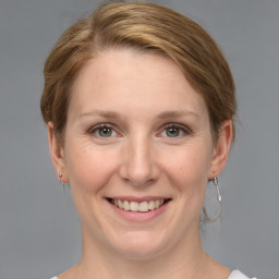 Joyful white young-adult female with medium  brown hair and grey eyes