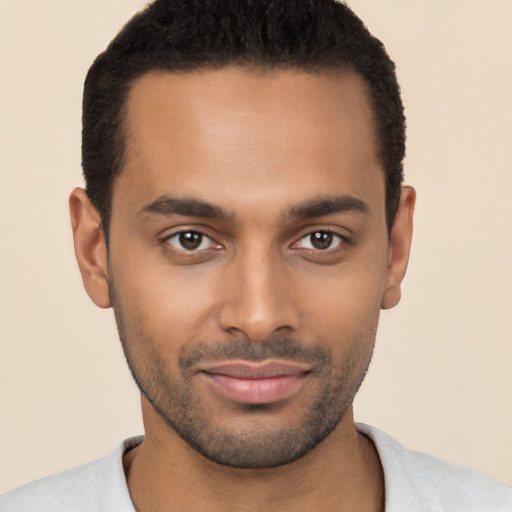 Joyful black young-adult male with short  black hair and brown eyes