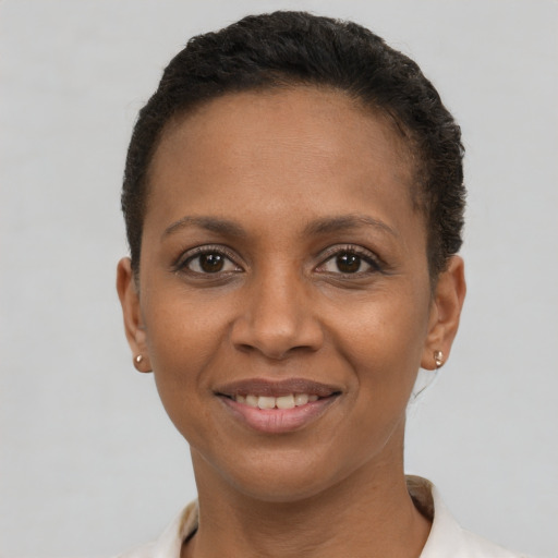 Joyful black young-adult female with short  brown hair and brown eyes