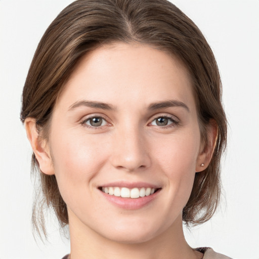 Joyful white young-adult female with medium  brown hair and grey eyes