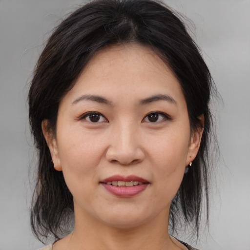 Joyful asian young-adult female with medium  brown hair and brown eyes