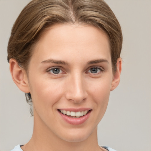 Joyful white young-adult female with short  brown hair and grey eyes