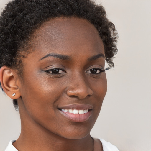 Joyful black young-adult female with short  brown hair and brown eyes