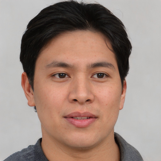 Joyful asian young-adult male with short  brown hair and brown eyes