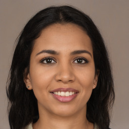 Joyful latino young-adult female with long  brown hair and brown eyes