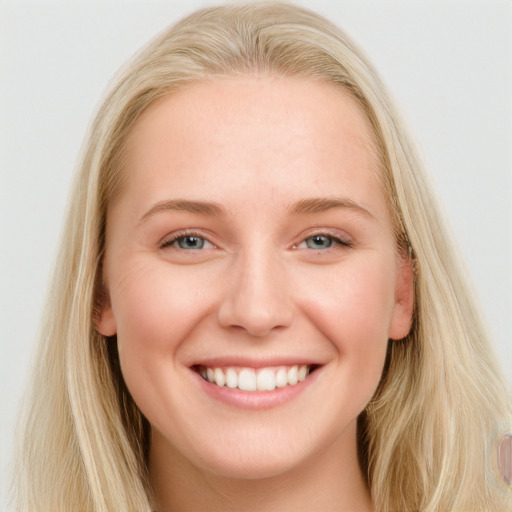 Joyful white young-adult female with long  brown hair and blue eyes