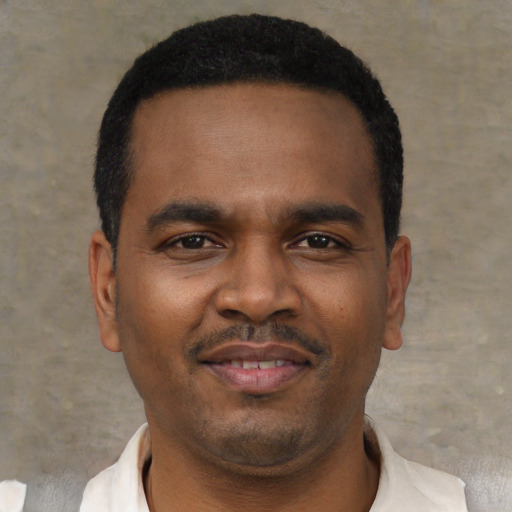 Joyful black young-adult male with short  black hair and brown eyes