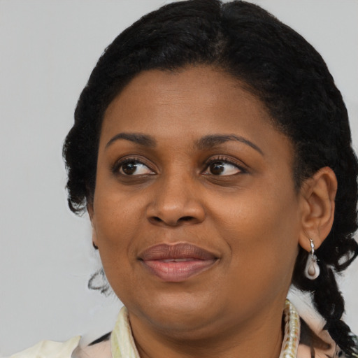 Joyful black adult female with short  black hair and brown eyes