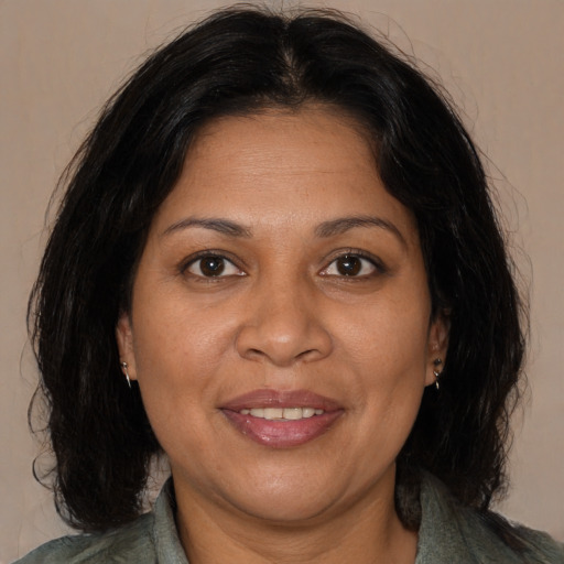 Joyful black adult female with medium  brown hair and brown eyes
