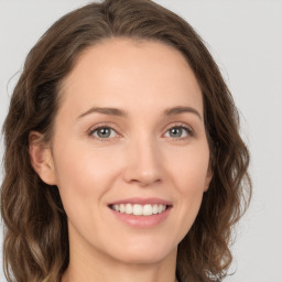 Joyful white young-adult female with long  brown hair and green eyes