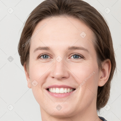 Joyful white young-adult female with medium  brown hair and green eyes