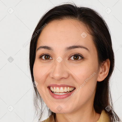 Joyful white young-adult female with long  brown hair and brown eyes