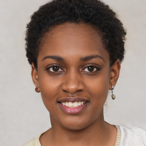 Joyful black young-adult female with short  black hair and brown eyes