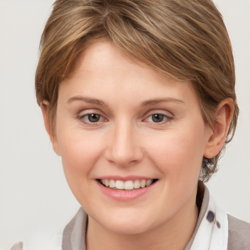 Joyful white young-adult female with medium  brown hair and grey eyes