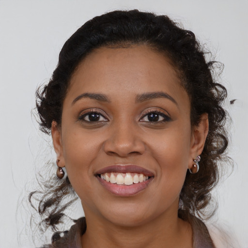 Joyful black young-adult female with medium  brown hair and brown eyes