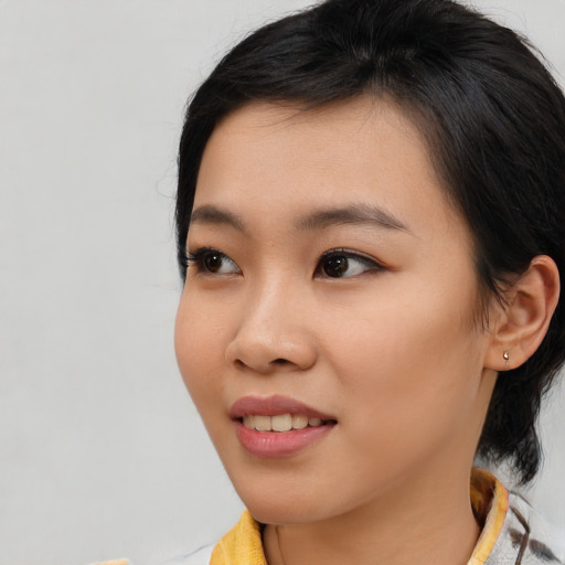 Joyful asian young-adult female with medium  brown hair and brown eyes