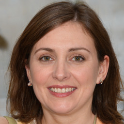 Joyful white adult female with medium  brown hair and blue eyes