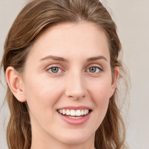 Joyful white young-adult female with long  brown hair and blue eyes