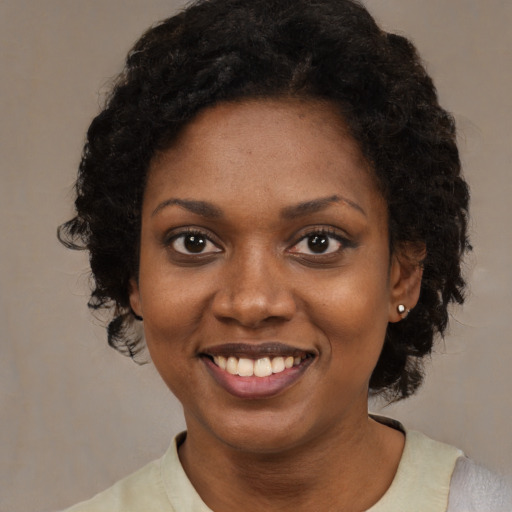Joyful black young-adult female with medium  black hair and brown eyes