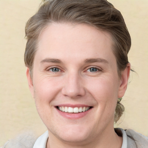 Joyful white young-adult female with short  brown hair and grey eyes