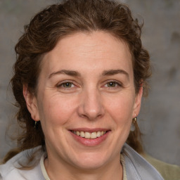 Joyful white adult female with medium  brown hair and grey eyes