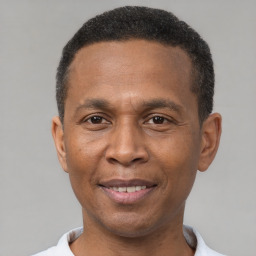 Joyful latino adult male with short  black hair and brown eyes