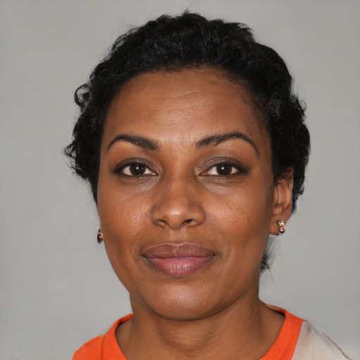 Joyful black adult female with short  black hair and brown eyes