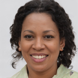 Joyful black adult female with long  brown hair and brown eyes