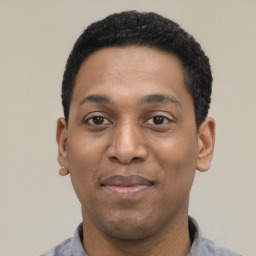 Joyful latino young-adult male with short  black hair and brown eyes