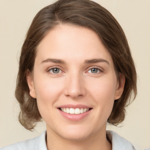 Joyful white young-adult female with medium  brown hair and green eyes