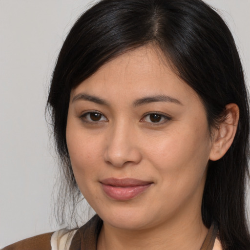 Joyful latino young-adult female with long  brown hair and brown eyes