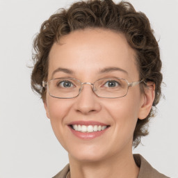 Joyful white adult female with medium  brown hair and green eyes