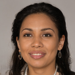 Joyful latino young-adult female with long  brown hair and brown eyes