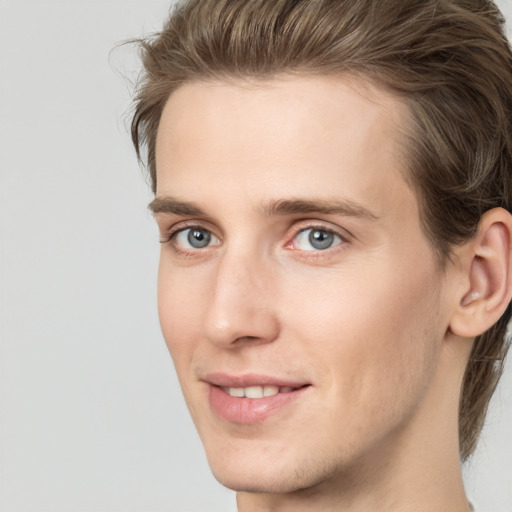 Joyful white young-adult male with medium  brown hair and grey eyes