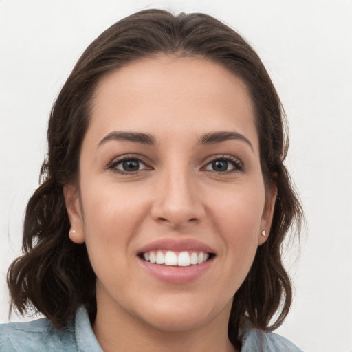 Joyful white young-adult female with medium  brown hair and grey eyes