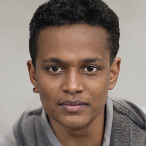 Joyful black young-adult male with short  black hair and brown eyes
