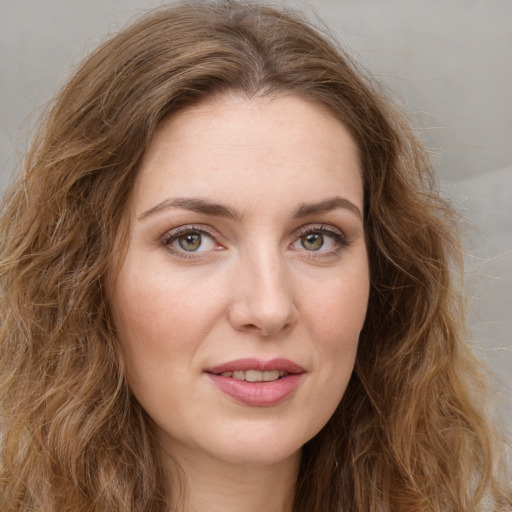 Joyful white young-adult female with long  brown hair and green eyes