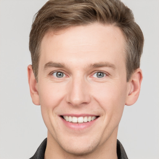 Joyful white young-adult male with short  brown hair and grey eyes