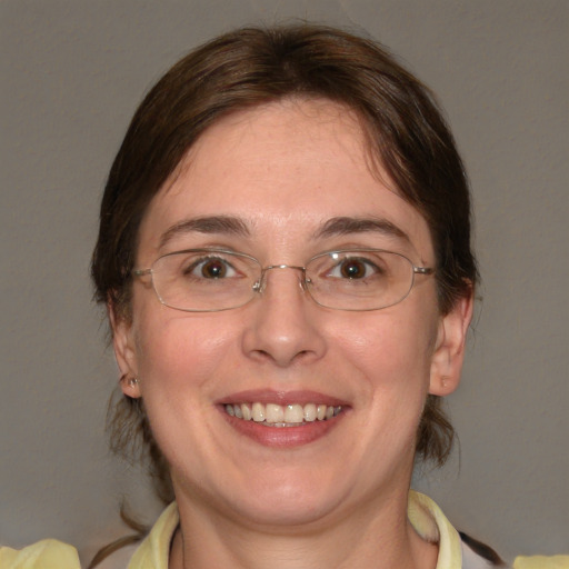 Joyful white adult female with medium  brown hair and green eyes