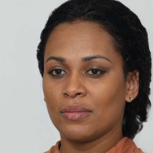 Joyful black young-adult female with medium  brown hair and brown eyes